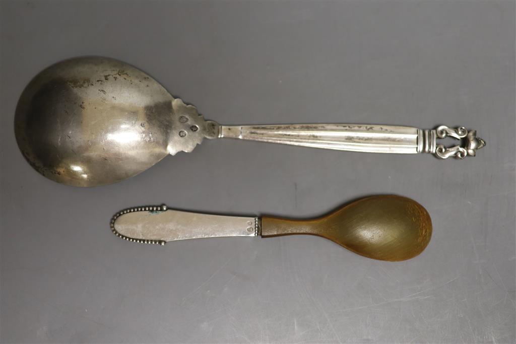 A 1920s Georg Jensen sterling Acorn pattern serving spoon, 23cm and one other Jensen spoon with horn bowl, gross 124 grams.